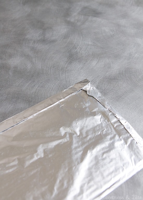 The long edge of the foil folded over to enclose the paper towels completely.