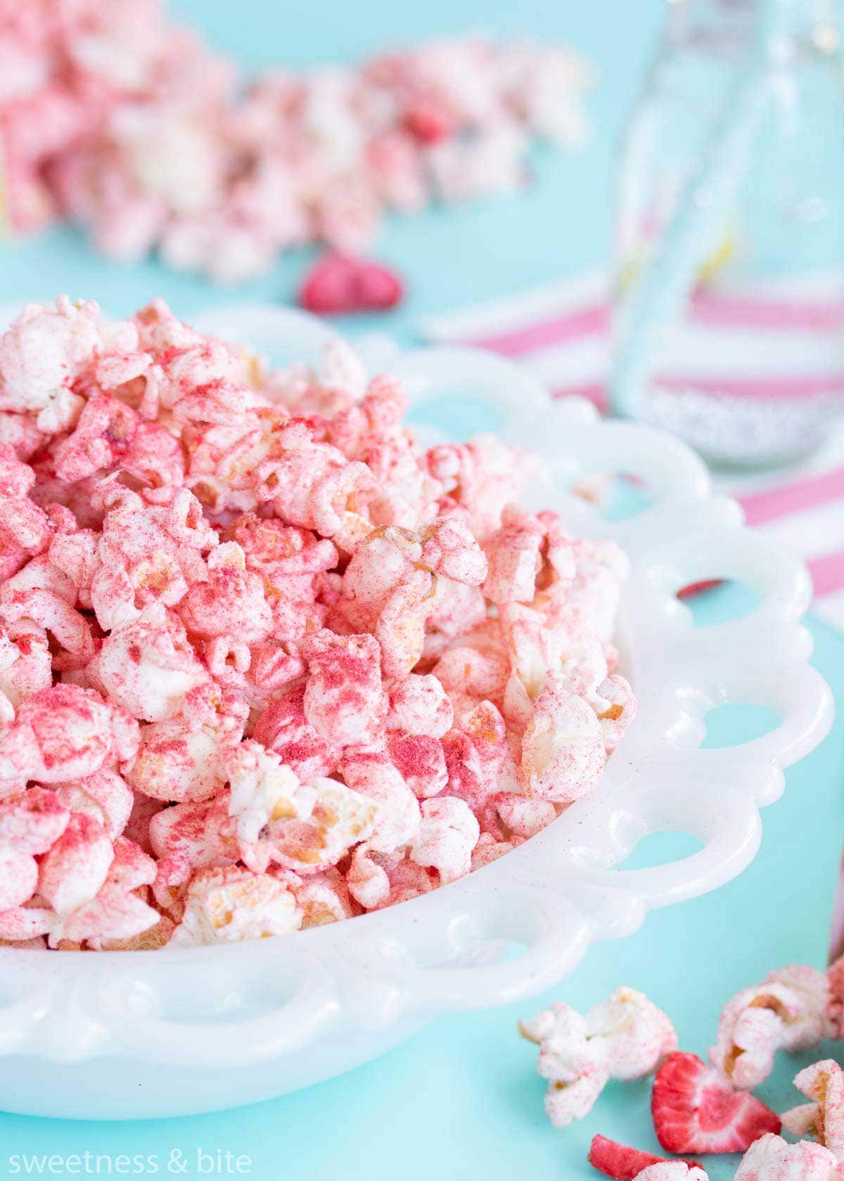 A white milk glass bowl full of fruit flavoured popcorn.