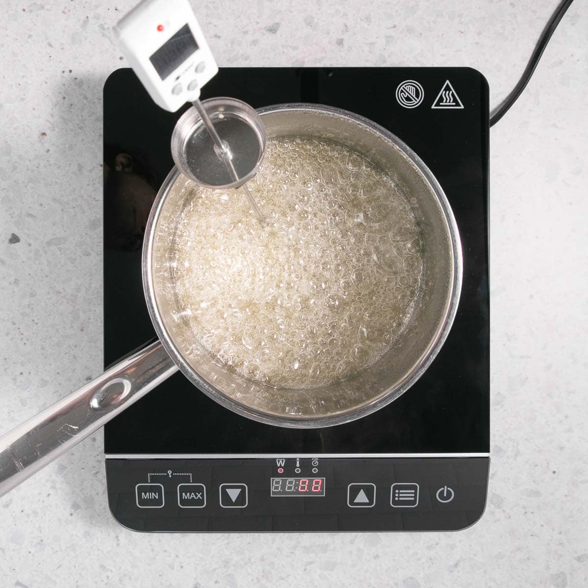 As above, with a thermometer clipped to the pan, and the liquid starting to boil.