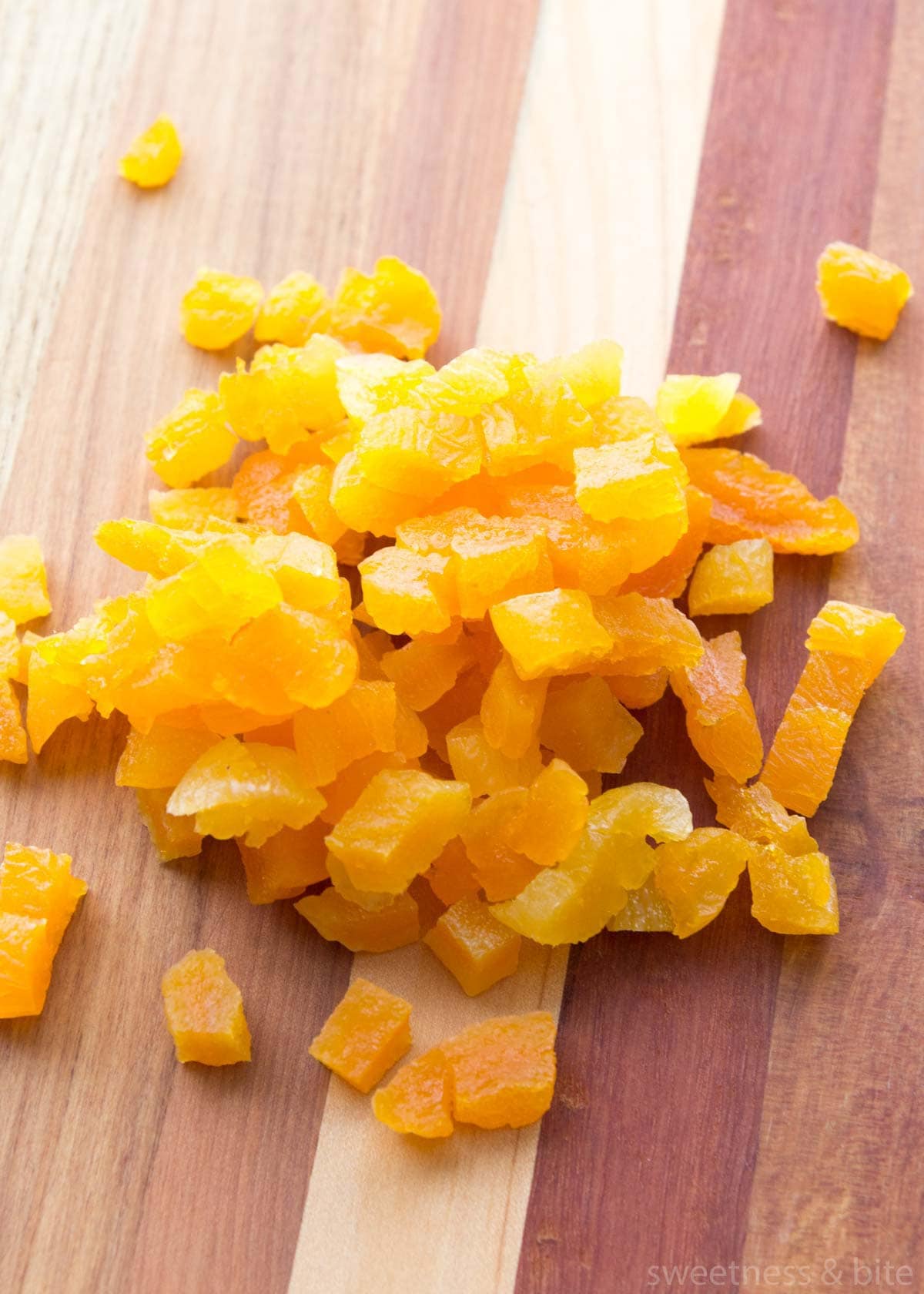 Chopped dried apricots on a wooden board.