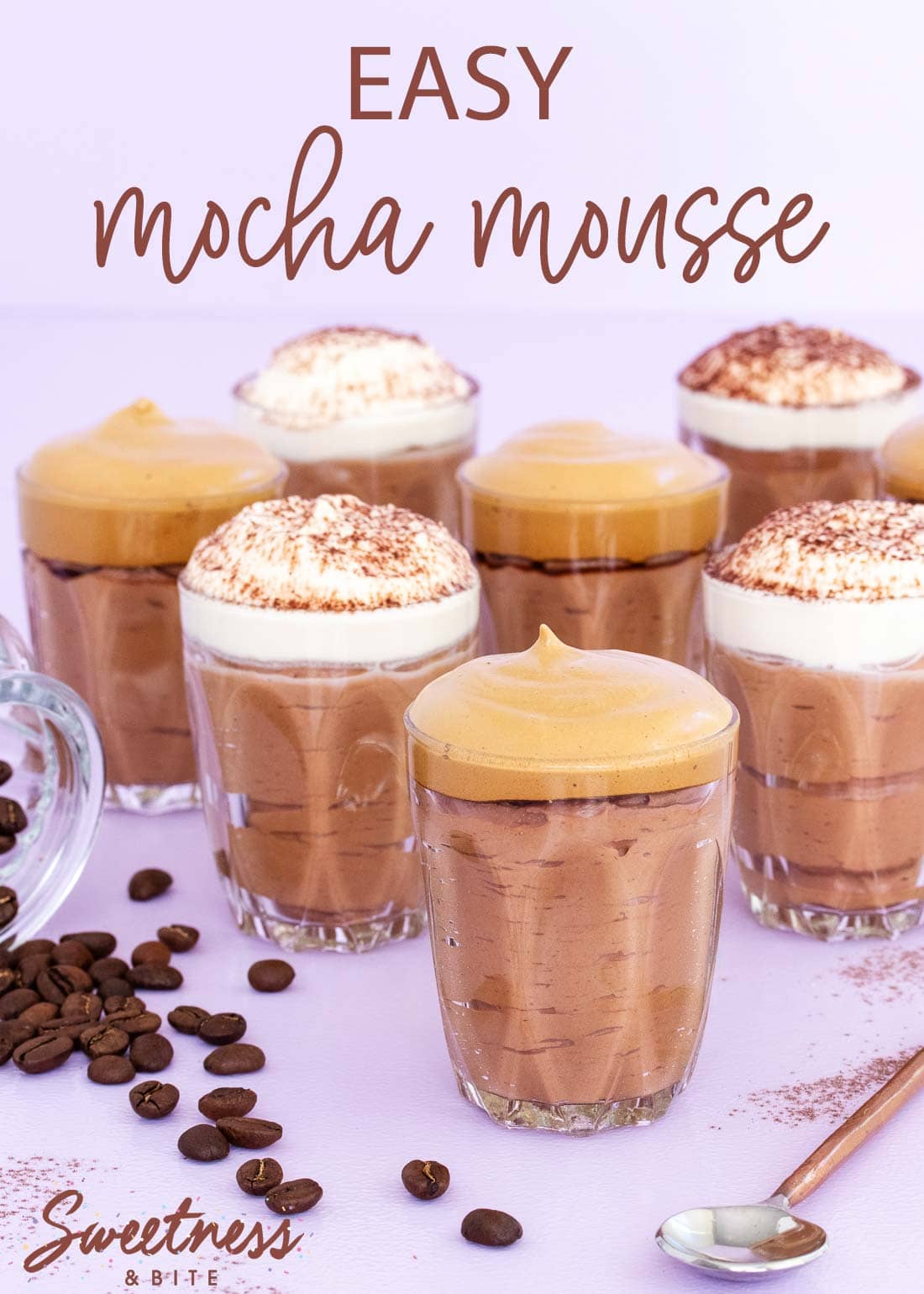 Small glasses of mocha mousse, some topped with whipped cream and some topped with whipped coffee.