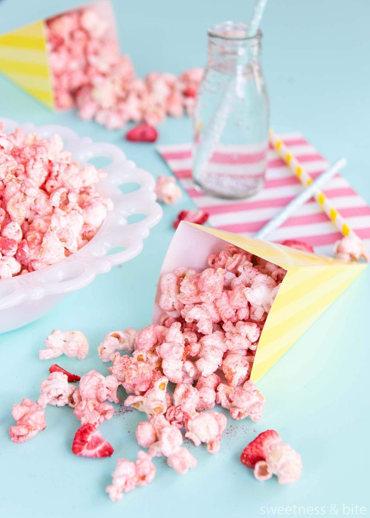 Flavoured popcorn in a yellow and white striped paper cone.