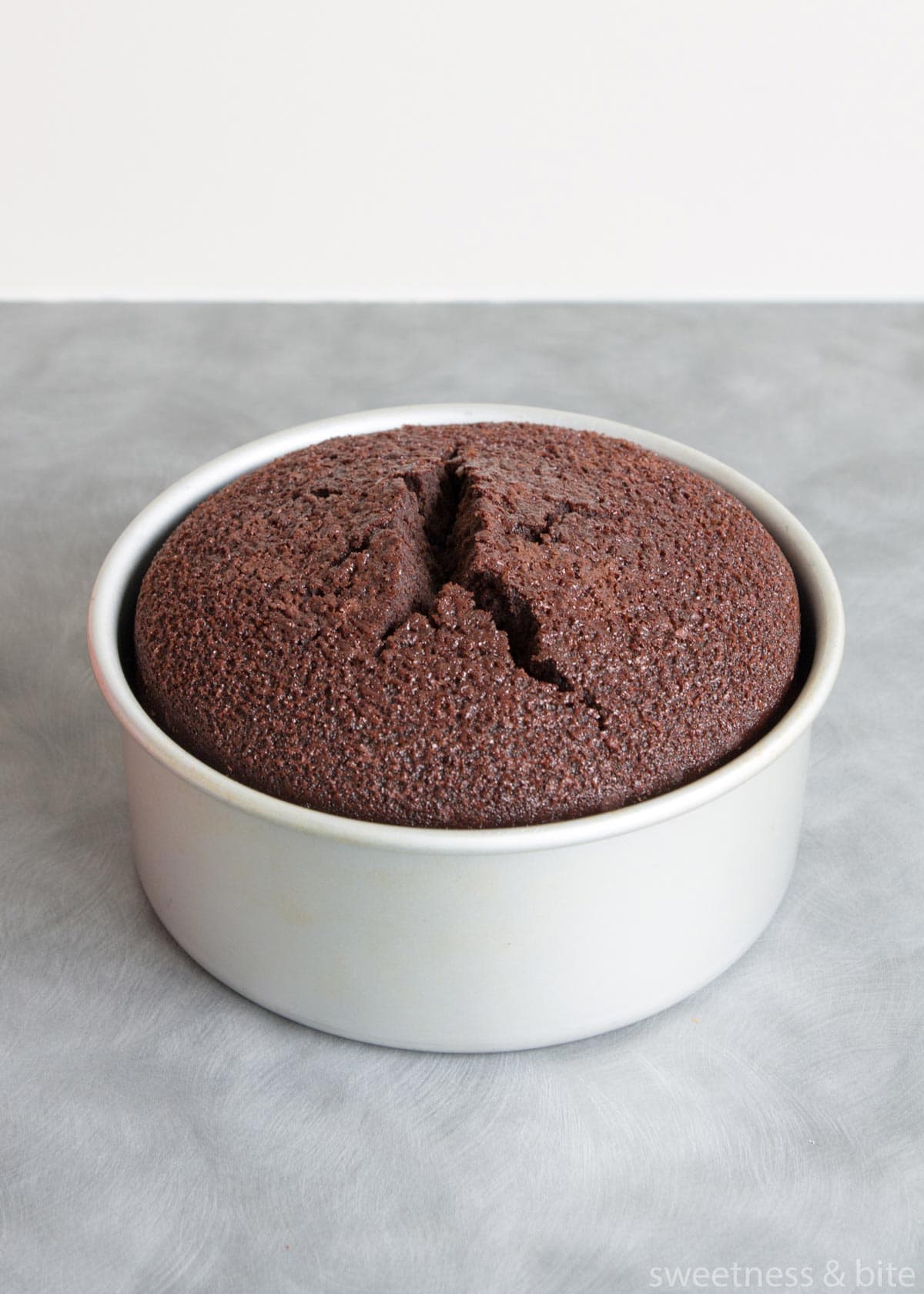 Gluten free dark chocolate mud cake with a cracked top.