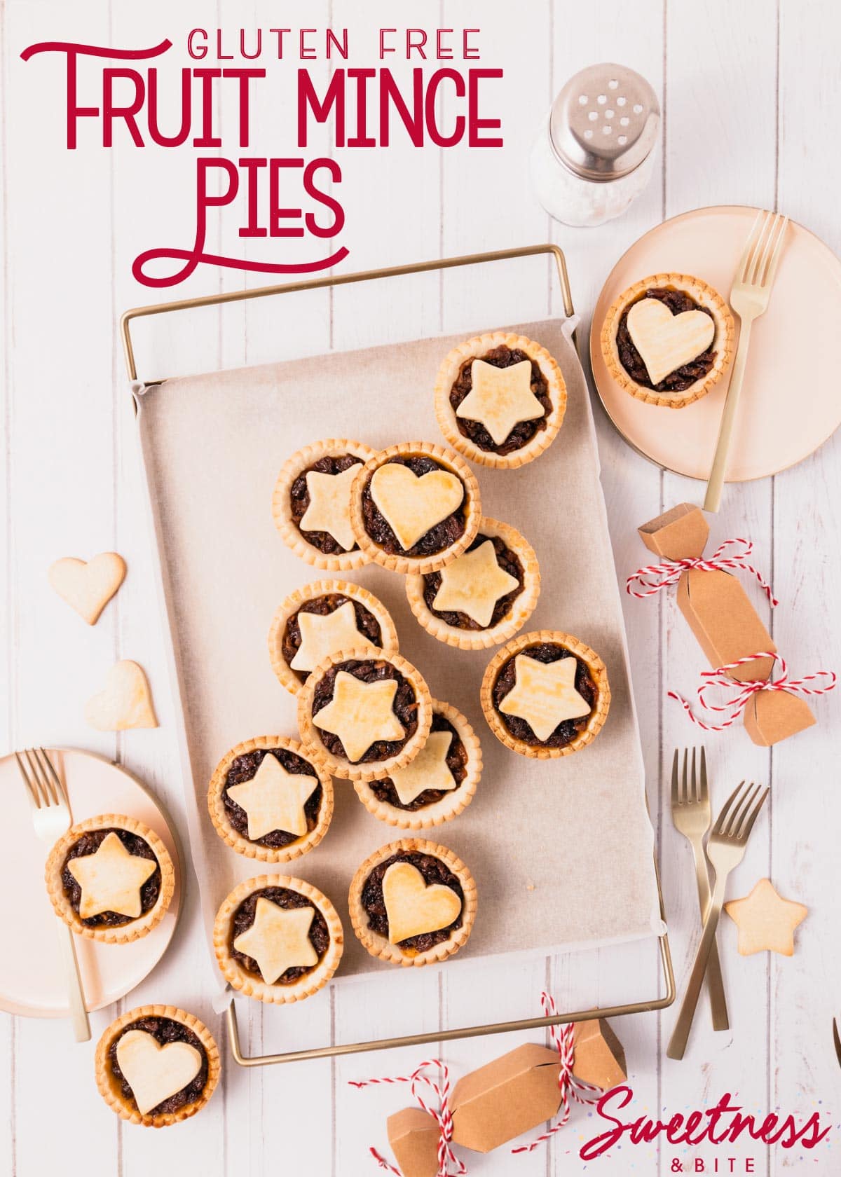 Mince pies arranged haphazardly on a gold metal tray, with pink and gold plates and gold cake forks, red text overlay reads 