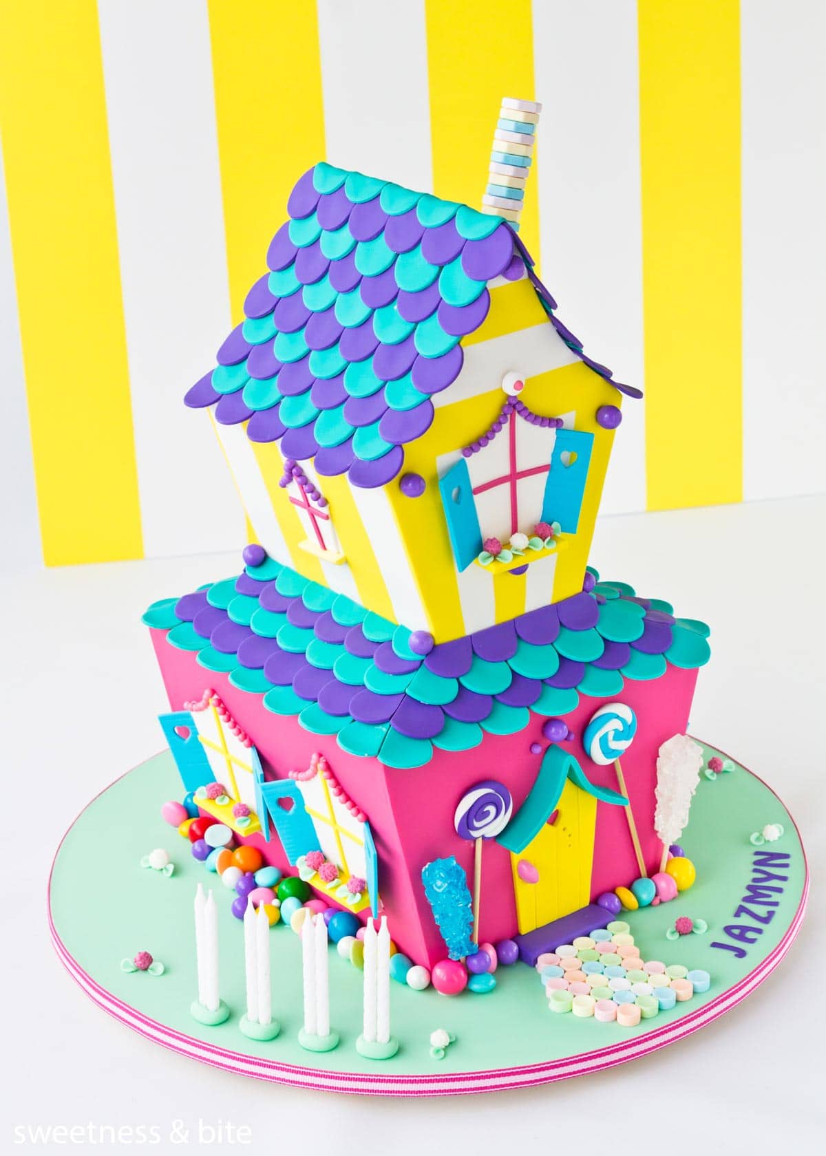 A brightly coloured two tier candy house cake.