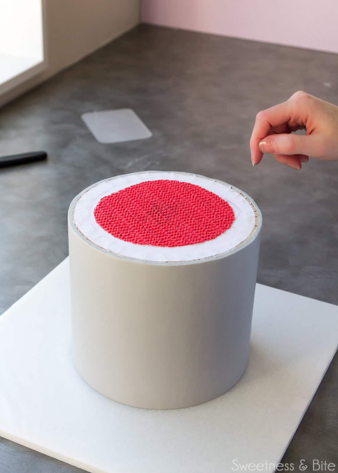 A round piece of non-slip mat on the cake board.