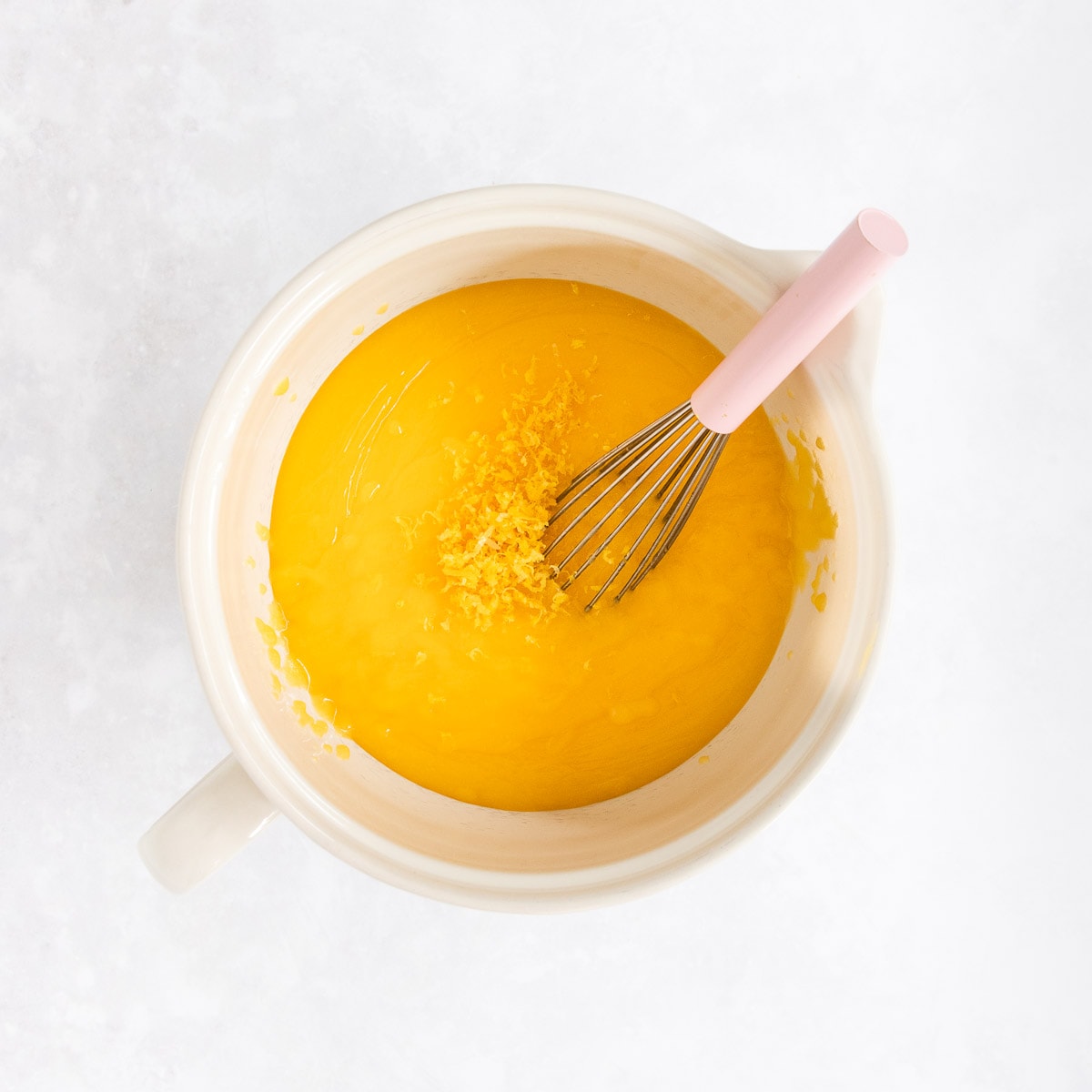 The lemon zest being added into the lemon curd.