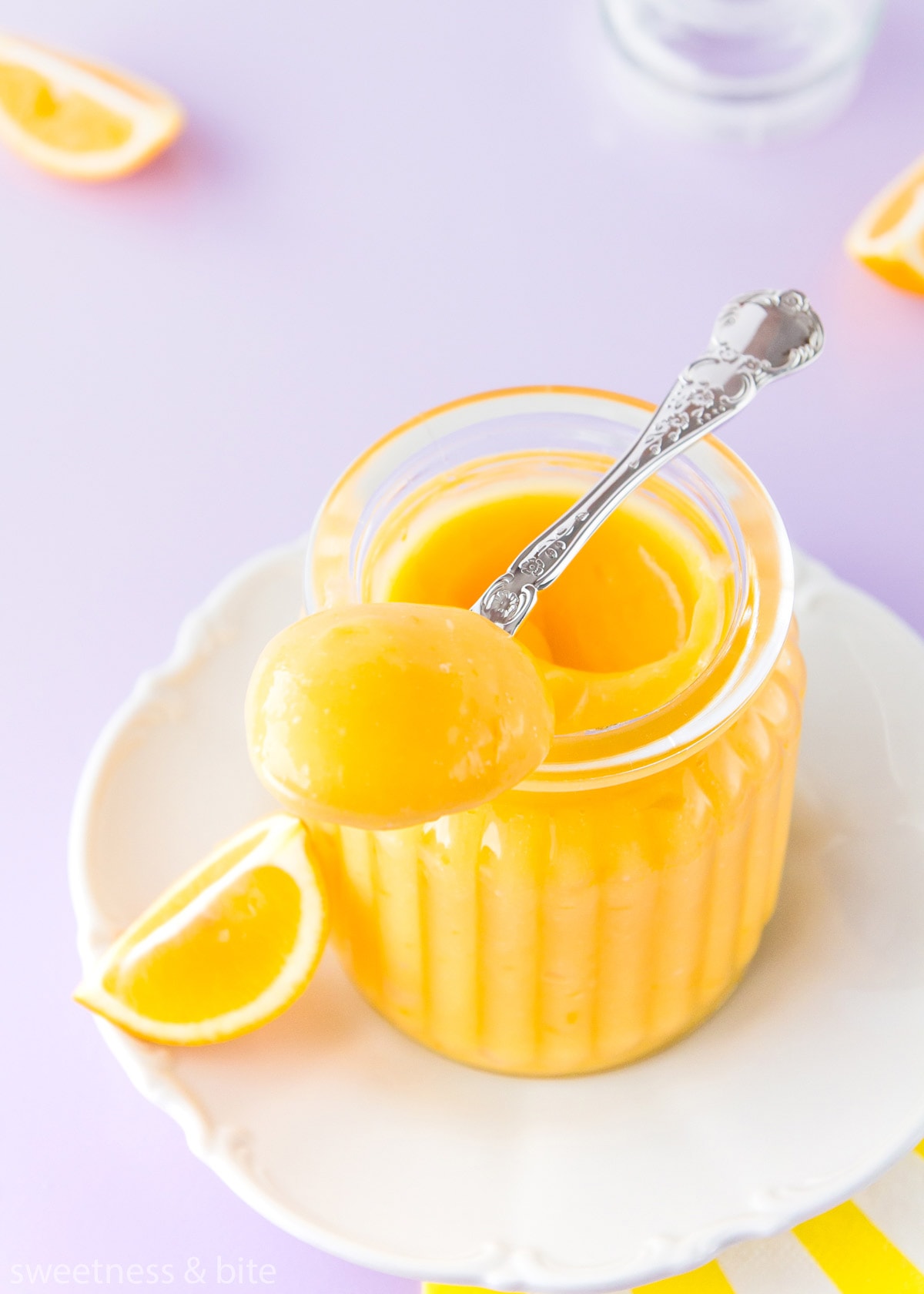 A spoonful of thick lemon curd resting on the top of a jar.